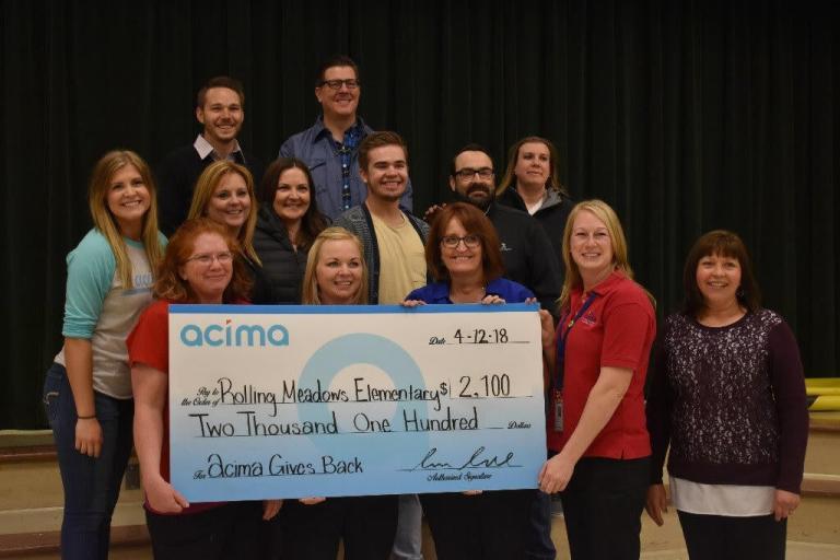 A group of teachers holding a large paper check